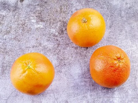 Three large grapefruits on a table Stock Photos
