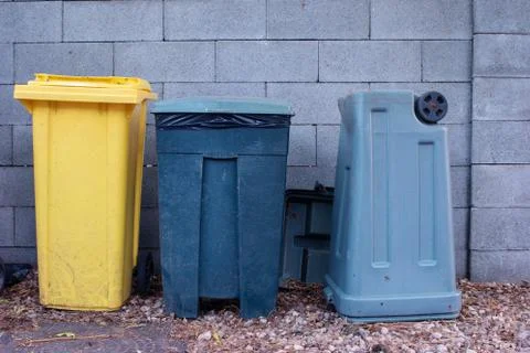 Three large old plastic trash cans in the back yard of a home Fotos de archivo