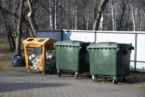 Three large trash cans in the park. One of them is for plastic Stock Photos