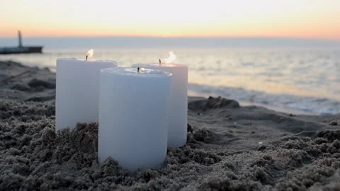 Three large white candles burning sand seaside beach in the morning or evening Stock Footage 306214408
