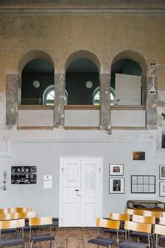 Three large windows, with a desk and chair at the bottom, is an academic Stock Photos