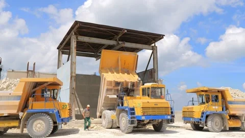 Three large yellow dump trucks dump stones for recycling. Mining industry. Heavy Video stock 156387938