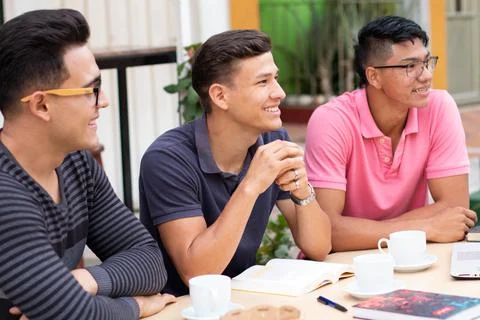 Three latin students looking at the same place and smiling Stock Photos