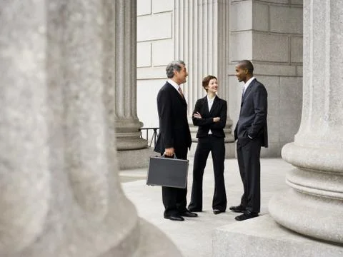 Three lawyers talking in front of a courthouse Foto stock