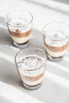 Three-layer chocolate and vanilla mousse dessert in glass cups, sprinkled with Stock Photos