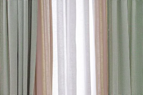 Three-layer curtains in beige, white linen fabric and goose foot fabric. Stock Photos