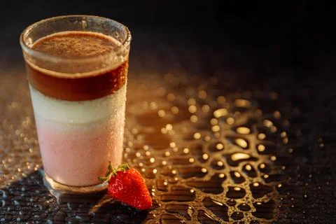 Three-layer light dessert in a glass. Three layers: coffee, cream, raspberry. Stock Photos