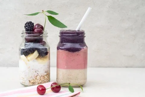 Three-layer smoothie of cherry, banana and blackberry with yogurt and oatmeal Stock Photos
