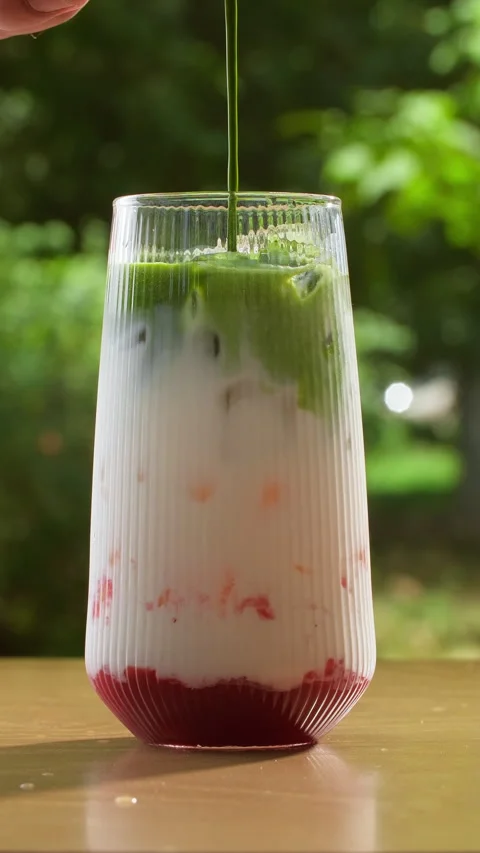 Three-layered berry-milk-matcha drink in a glass. Red berry puree, creamy milk Stock Footage 316172859