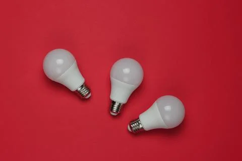 Three LED light bulbs on a red background. Top view 写真素材