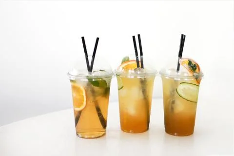Three lemonades on white table in plastic cups Stock Photos