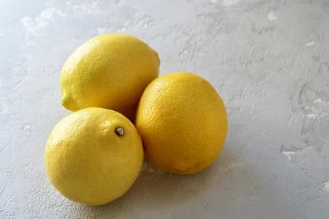 Three lemons on a grey concrete background with a copy of space. Foto stock