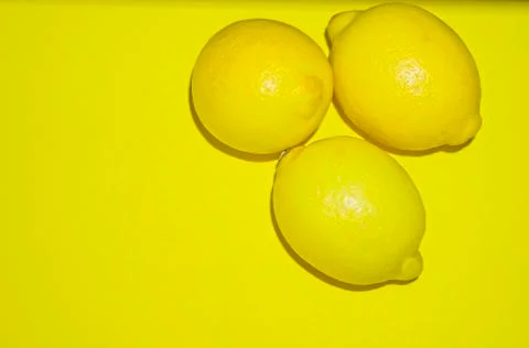 Three lemons isolated on yellow background Foto stock