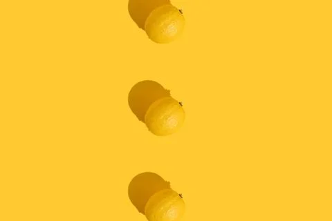 Three lemons on a yellow background with a hard shadow. The concept of summer Stock Photos