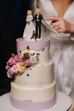 Three-level wedding cake with figures of people on it Fotos Stock