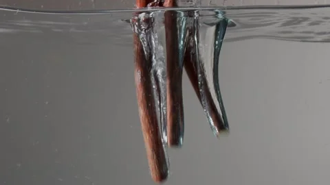 Three licorice cticks falling into the water Underwater slow motion Stock Footage 132890064