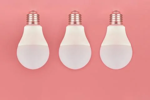 Three light bulbs, copy space. Energy saving minimal idea concept.Pink backgr Stock Photos