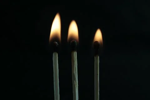 Three lighted matches on a black background, beautiful fire Stock Photos