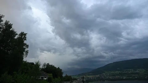 Three lightning strikes hit mountains behind Voss Norway during dramatic summer Stock Footage 313613242
