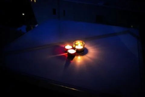 Three lit candles create a romantic atmosphere Stock Photos