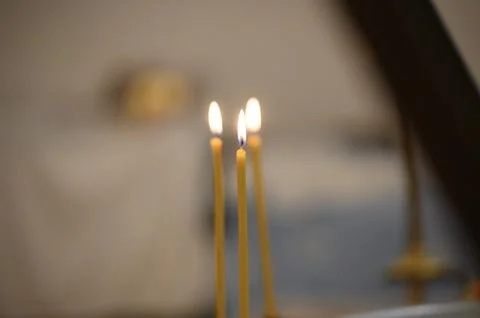 Three lit candles with soft background in a serene indoor setting 스톡 사진