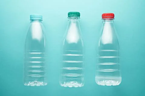 Three liter Plastic bottles of different shapes with lids on turquoise, neo m Stock Photos