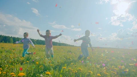 Three little boys exploding party cracker and catching confetti Stock Footage 79453522
