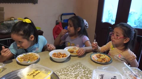 Three little cousins eating at the table watching distractedly at tv 스톡 동영상 154813854