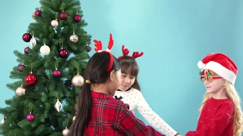 Three Little Girls Dancing in a Circle Near Christmas Tree Stock Footage 344782393
