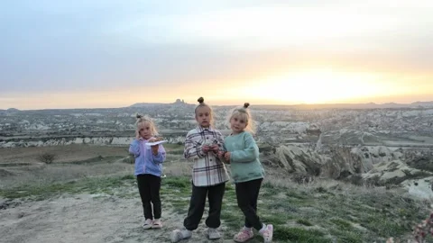 Three little sisters posing in front of balloons in Cappadocia turkey 库存影片 311915045