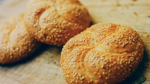 Three loaves of freshly baked bread in a round shape. In the background is a Stock Footage 231060050