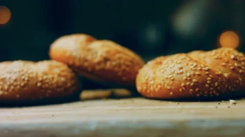 Three loaves of freshly baked bread in a round shape. In the background is a Stock Footage 231060112