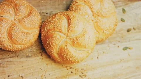 Three loaves of freshly baked bread in a round shape. In the background is a Stock Footage 231060404