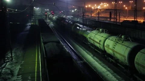 Three long freight trains move on railway at winter night Stock Footage 52450850
