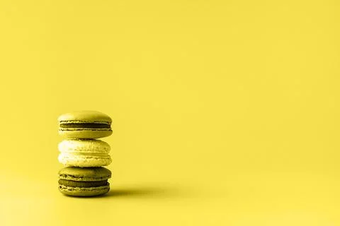 Three macaroons in stack toned in trendy yellow. Trendy background for your d Stock Photos