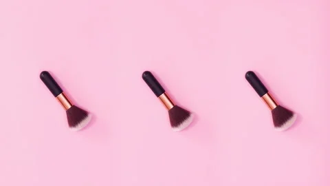 Three make up brushes rotating on bright pink background. Stop motion Video stock 155036464