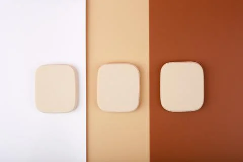 Three make up sponges on white, beige and brown background Stock Photos