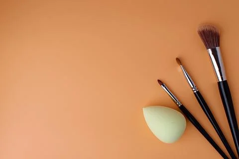 Three makeup brushes, brushes for blush, eyeshadow and lipstick and sponge Stock Photos