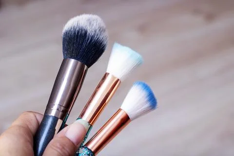 Three makeup brushes on gray background closeup Stock Photos