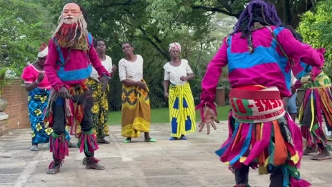 Three Malawian men in masks performing a traditional dance. Stock Footage 334411264