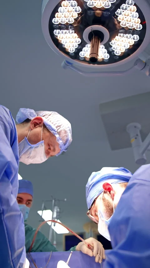 Three male medics leaned over the operating table.  Stock Footage 285072383