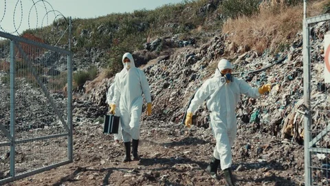 Three male scientists in white protective costumes investigating dangerous Video stock 113927680