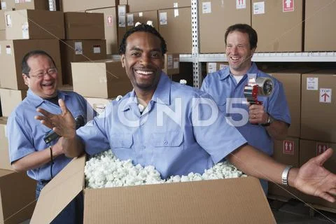 Three male warehouse workers joking around Stock Photos