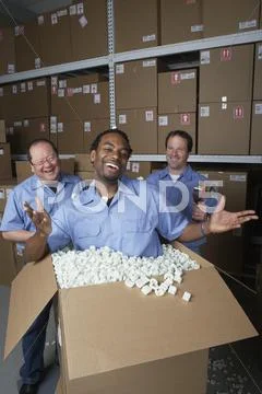 Three male warehouse workers joking around Stock Photos