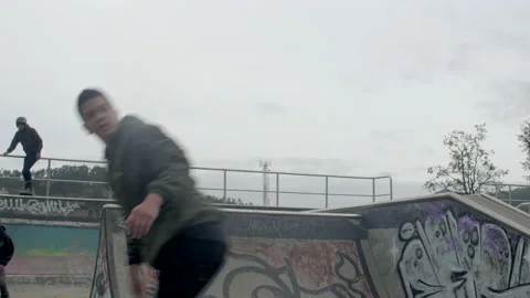Three males jump and spin at skatepark Stock Footage 171490827