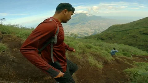 Three Man Running Down The Hill With View of Mount Covered in Lenticular Clouds Stockbeeldmateriaal 152788031