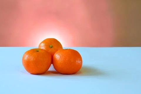 Three mandarins on a blue table. Foto stock