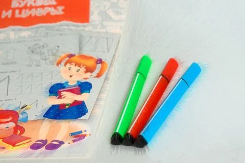 Three of the marker lying next to a notebook for school children, coloring. p Stock Photos
