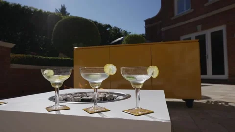 Three martinis are on a table with a yellow background Stock Footage 297870845