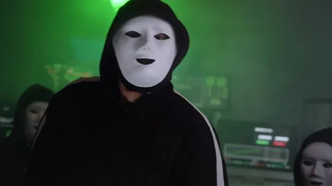 Three masked hackers sit in a darkroom. Computer criminals in secret subway Stock Footage 244595890